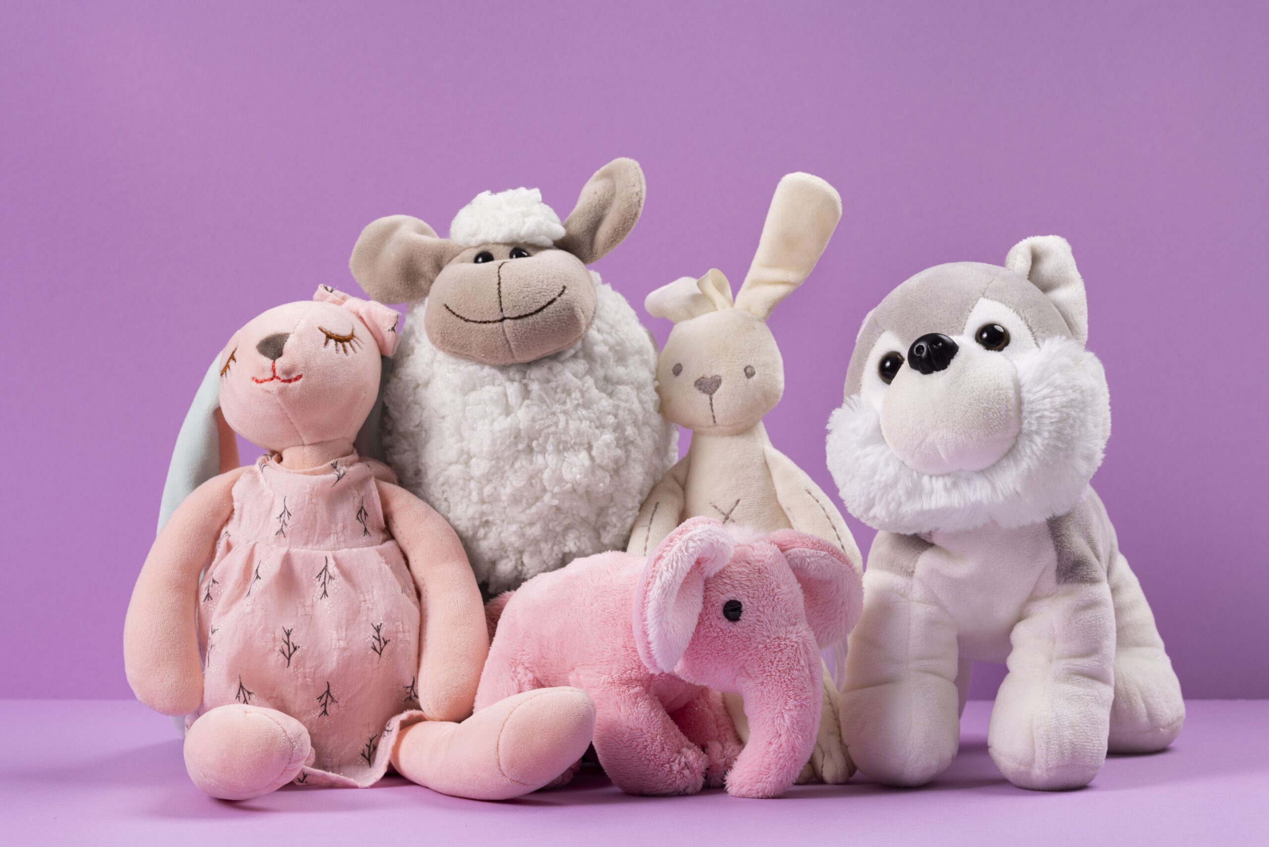 “Cute pastel plush toys arranged together on a soft background”